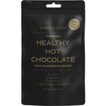 A black pouch labeled Golden Grind Turmeric Hot Chocolate Blend 100g—vegan, delicious, and all-natural with 100% organic ingredients including curcumin and Ceylon cinnamon. Superfood spices. Great for kids. Net weight: 100g.