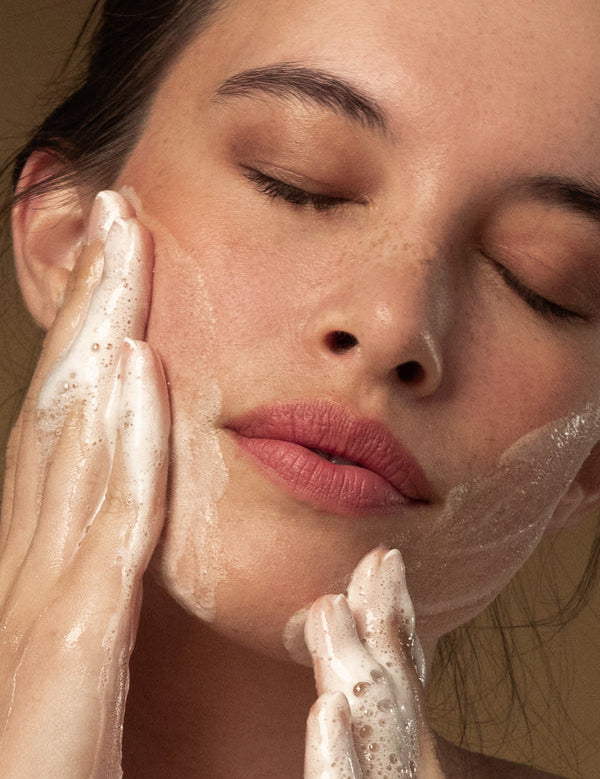 Model washing her face with Antipodes Gospel Vitamin C Skin-Glow Gel Cleanser