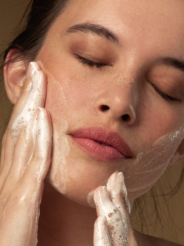 Model washing her face with Antipodes Gospel Vitamin C Skin-Glow Gel Cleanser