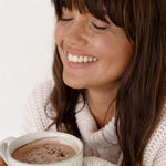 Woman enjoying a mug of Nutra Naturals Collagen Hot Chocolate