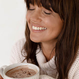 Woman enjoying a mug of Nutra Naturals Collagen Hot Chocolate