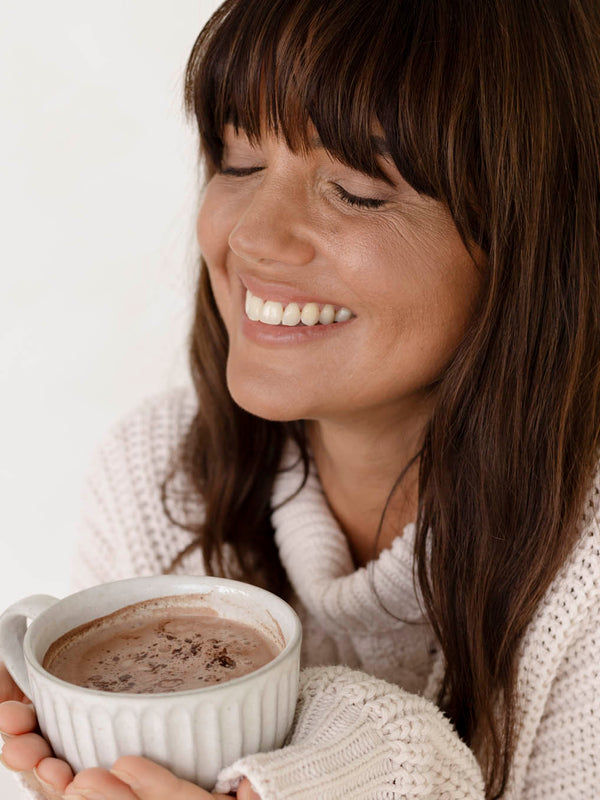Woman enjoying a mug of Nutra Naturals Collagen Hot Chocolate