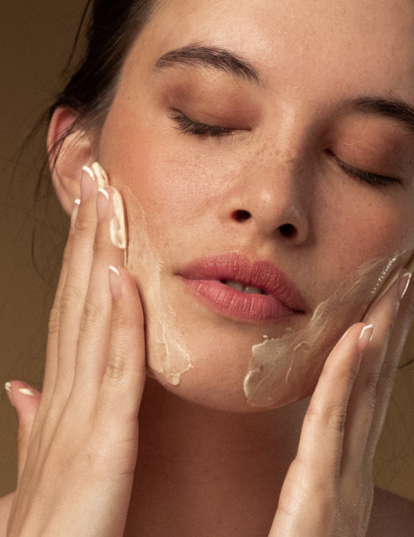 Model cleansing her face with Antipodes Hallelujah Lime and Patchouli Cleanser