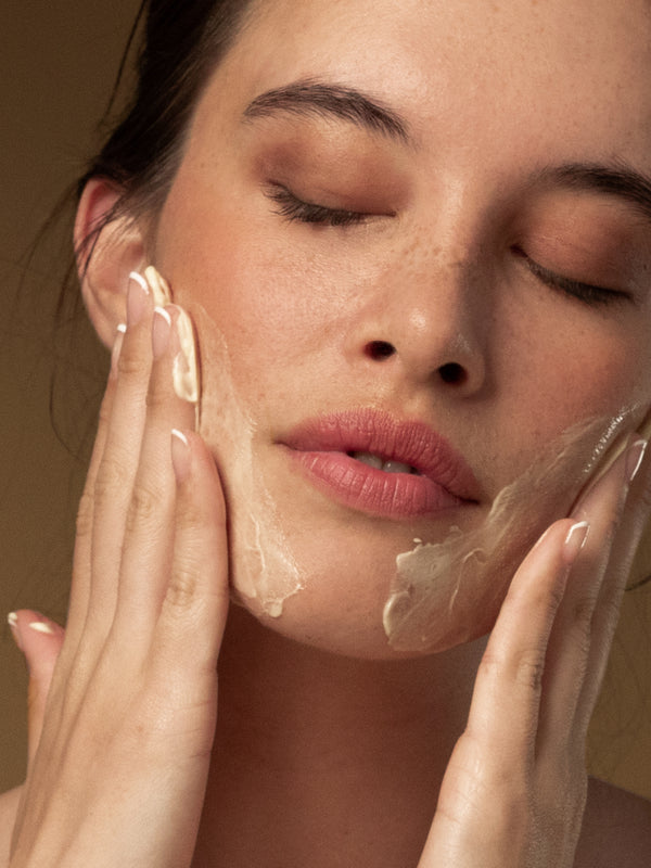 Model cleansing her face with Antipodes Hallelujah Lime and Patchouli Cleanser