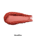 A swatch of pinkish-red 100% Pure Fruit Pigmented® Blush 9g by 100% Pure is smeared on white, with "Healthy" beneath—ideal for a natural flush and vegan-friendly cheeks.