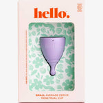 The Hello Period Cup Small, made from hypoallergenic, medical-grade TPE, is shown in floral packaging labeled "hello." The box indicates it's B Corp certified and suited for small, average cervix. Green floral patterns appear on a white background.
