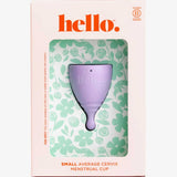The Hello Period Cup Small, made from hypoallergenic, medical-grade TPE, is shown in floral packaging labeled "hello." The box indicates it's B Corp certified and suited for small, average cervix. Green floral patterns appear on a white background.