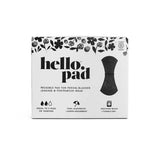 A white box labeled Hello Reusable Period Pad with black floral designs displays a pad for periods, bladder leaks, and postpartum use. Features leakproof tech, super absorbency, is machine washable, and safe for tumble drying.