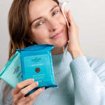 Woman cleansing her face while holding Wotnot natural face wipes