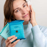 Woman cleansing her face while holding Wotnot natural face wipes
