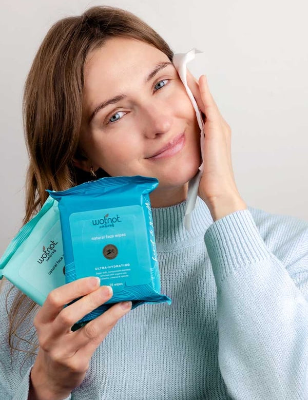 Woman cleansing her face while holding Wotnot natural face wipes
