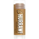 A 4.8g tube of Hurraw! Organic Lip Balm in Chocolate flavor, with a brown label featuring a cocoa bean illustration, stands upright against a white background.