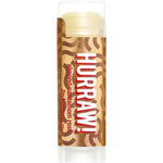 A 4.8g Hurraw! Vata Lip Balm Almond Cardamom & Rose stands upright on a white background, featuring a brown and gold wavy label—an organic lip balm inspired by almond, cinnamon, cardamom, and rose notes.