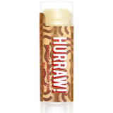 A 4.8g Hurraw! Vata Lip Balm Almond Cardamom & Rose stands upright on a white background, featuring a brown and gold wavy label—an organic lip balm inspired by almond, cinnamon, cardamom, and rose notes.