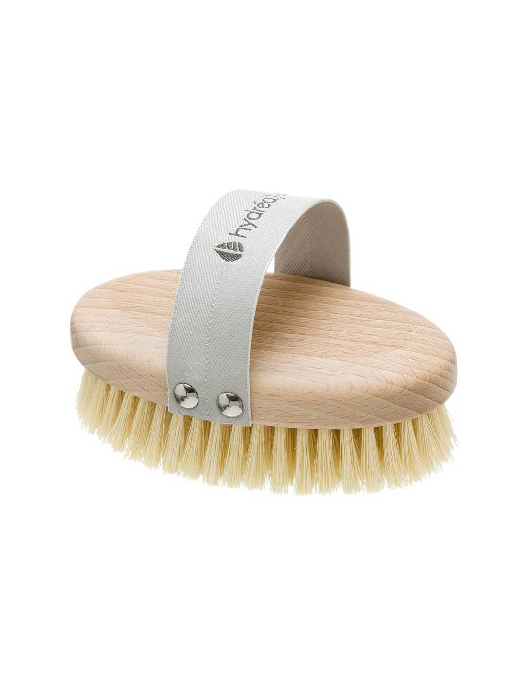 The Hydrea Professional Vegan Dry Body Brush features an oval shape, light bristles, and a gray fabric strap with metal rivets for easy grip—perfect for dry brushing routines. Shown on a white background.