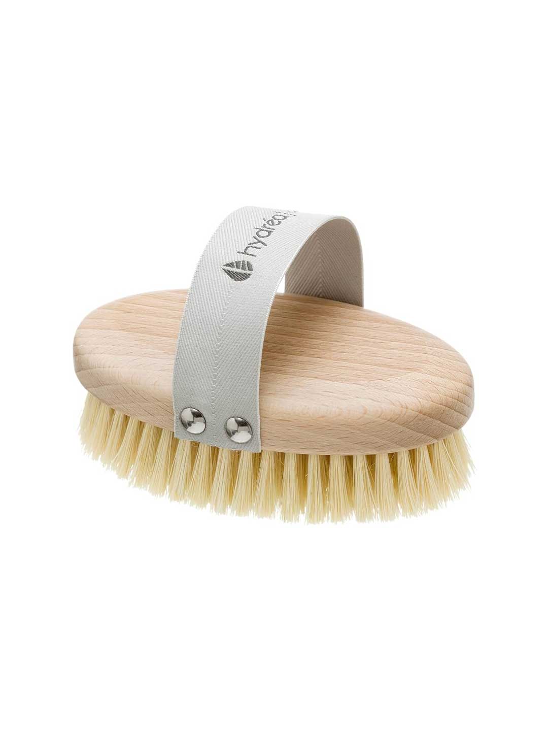 The Hydrea Professional Vegan Dry Body Brush features an oval shape, light bristles, and a gray fabric strap with metal rivets for easy grip—perfect for dry brushing routines. Shown on a white background.