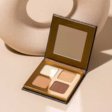 The INIKA Organic Brow Palette 8g, an open vegan palette with four neutral shades and a mirror, is shown on a beige surface next to a round, textured decor object—ideal for creating versatile brow looks.