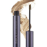 A tube of INIKA Organic Brow Perfector 6.5ml with its wand applicator removed sits in front of a light brown swatch. The shade name "Birch" is displayed below the image.