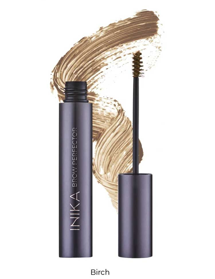 A tube of INIKA Organic Brow Perfector 6.5ml with its wand applicator removed sits in front of a light brown swatch. The shade name "Birch" is displayed below the image.