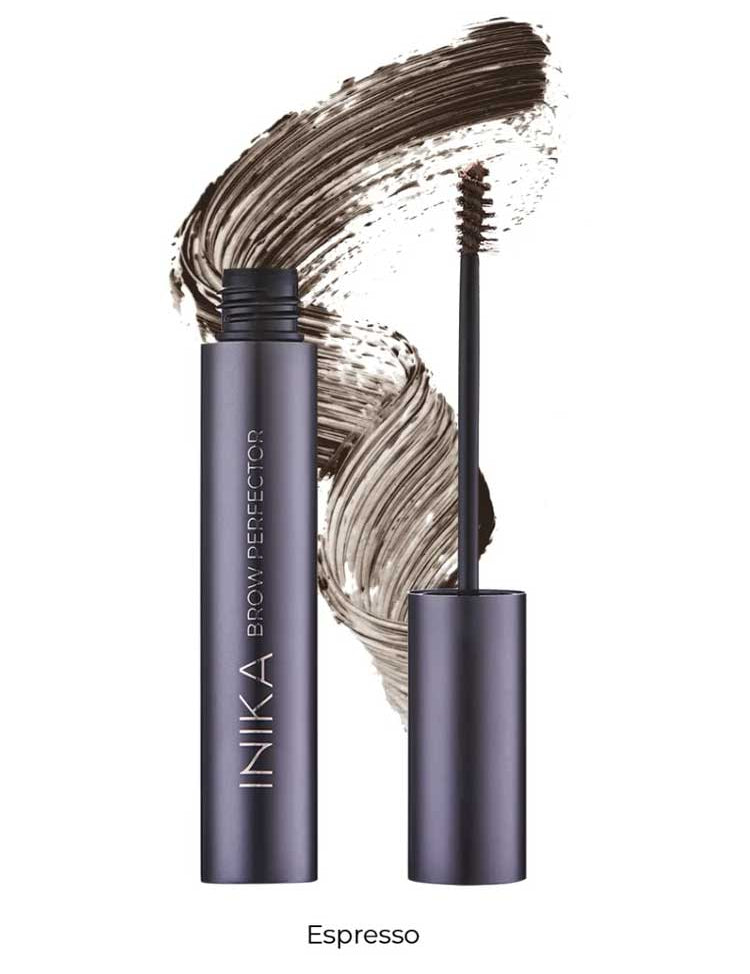 A tube of INIKA Organic Brow Perfector 6.5ml in Espresso, uncapped to show the brush applicator, displayed in front of a brown natural eyebrow gel swatch.