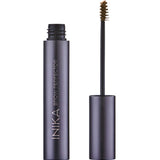 The INIKA Organic Brow Perfector 6.5ml stands upright without its cap, revealing a small brush applicator coated in brown product against a white background.
