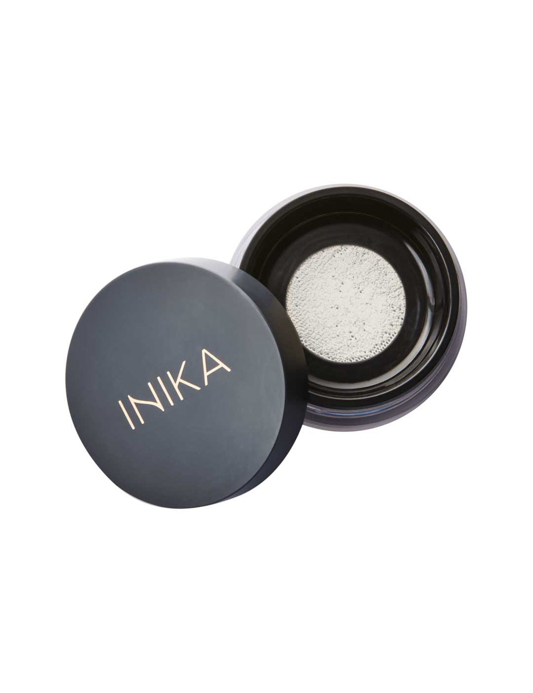 The INIKA Organic Mattify Mineral Setting Powder 7g comes in a sleek black round container, partially open to show its light mineral powder—ideal for completing your organic makeup routine.