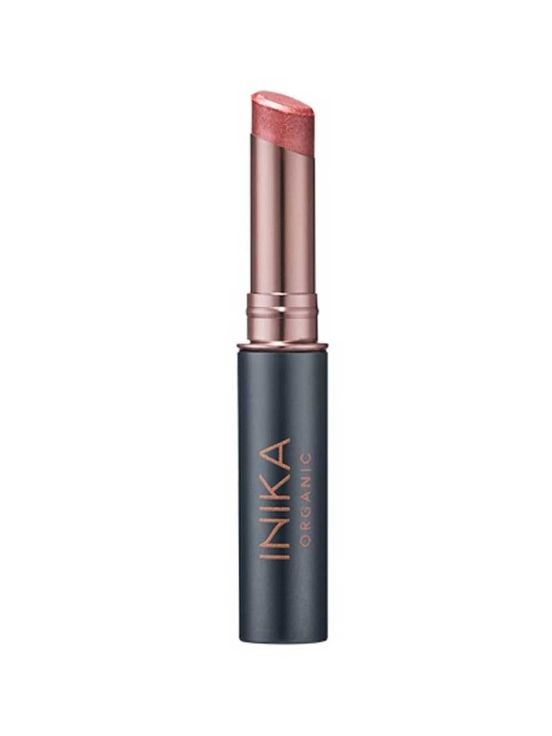 A partially opened INIKA Organic Tinted Lip Balm - Rose 3.5g in a rose gold and black tube reveals its shimmery pink tint, with the INIKA ORGANIC brand name displayed vertically on the casing.
