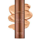 A bottle of INIKA Organic Organic BB Cream 30ml in the shade Honey, a vegan beauty balm, is displayed in front of a creamy tan swatch showcasing its natural satin finish.