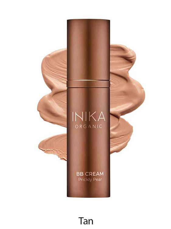 A bronze bottle of INIKA Organic Organic BB Cream 30ml in shade Tan, a vegan satin-finish beauty balm, is displayed with its creamy tan product swatched behind it.