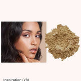 A woman with medium-dark skin and olive undertones poses beside INIKA Organic Loose Mineral Foundation SPF25 8g in Inspiration (Y8), ideal for medium-dark skin with olive undertones.