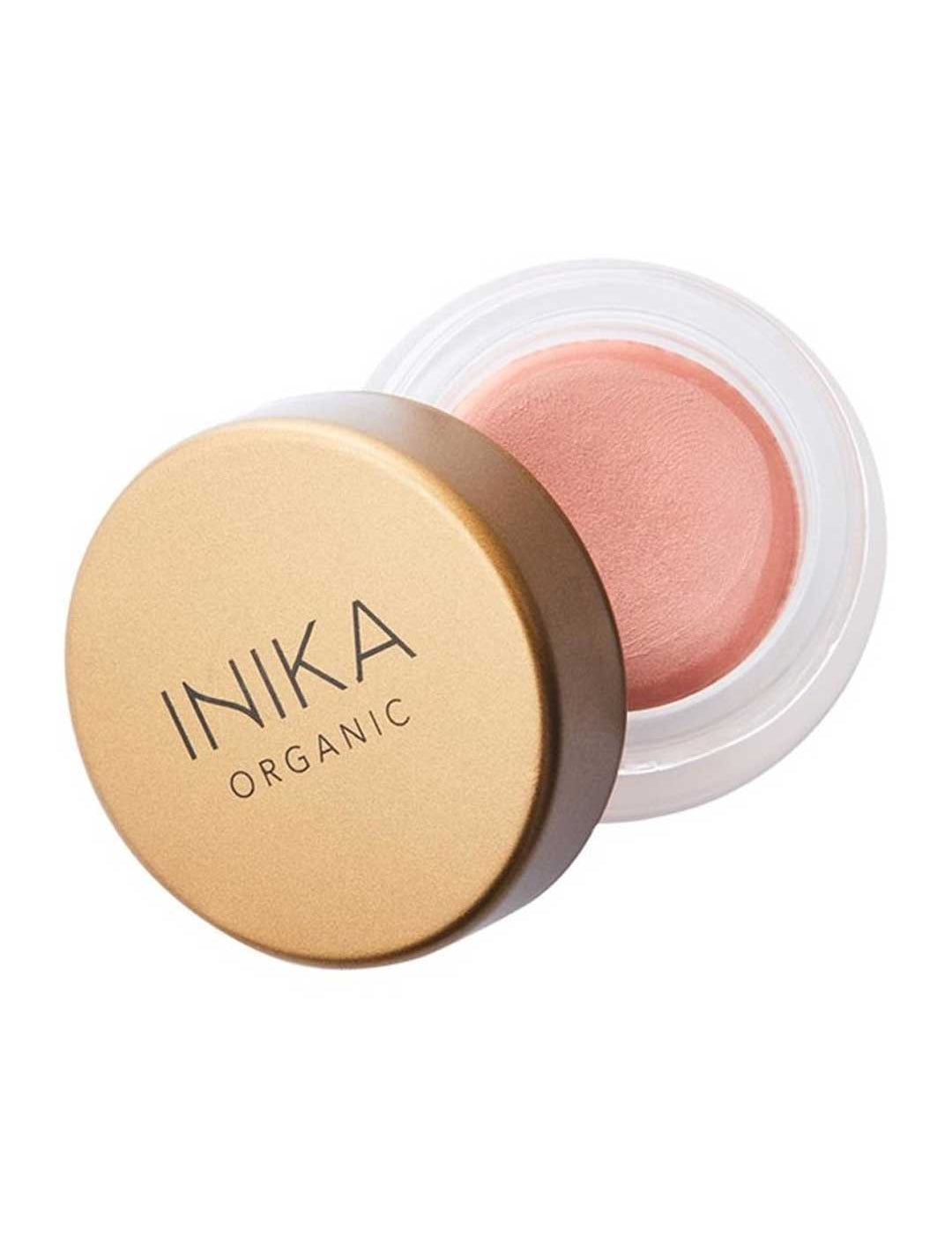 A small round container of INIKA Organic Lip & Cheek Cream Dusk 3.5g with a gold lid, partially open to show the soft pink vegan formula inside, perfect for a dewy finish on lips and cheeks.