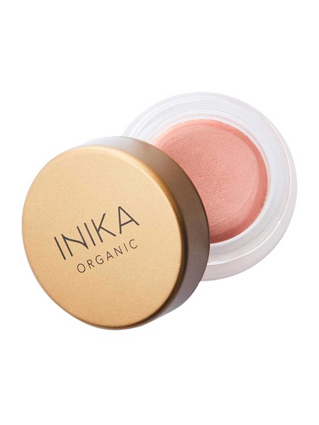 A small round container of INIKA Organic Lip & Cheek Cream Dusk 3.5g with a gold lid, partially open to show the soft pink vegan formula inside, perfect for a dewy finish on lips and cheeks.