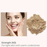 A smiling, light-skinned woman touches her face next to INIKA Organic Loose Mineral Foundation SPF25 8g. Text: Strength (N3)—for light skin with warm undertones. Non-comedogenic and SPF25 for daily protection.