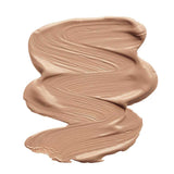 A smooth, thick swatch of INIKA Organic Liquid Foundation 30ml in a tan shade is smeared in a zigzag pattern on a white background, with the word "Tan" below the swatch.