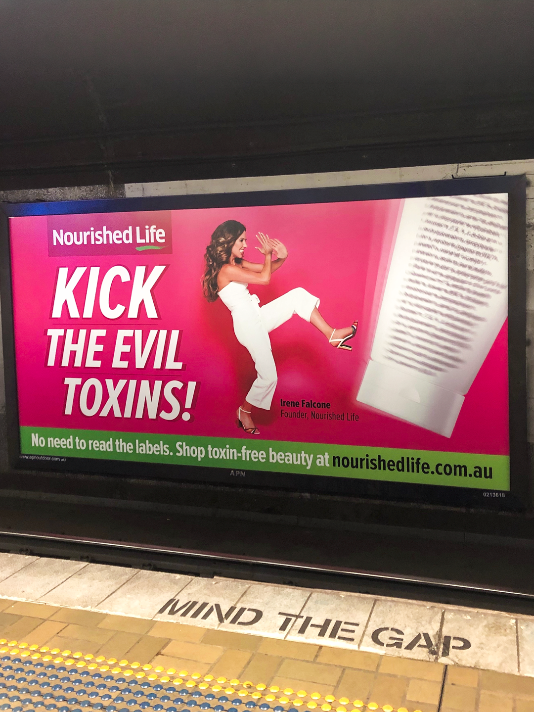 Irene on a train-station billboard kicking a giant toxin-laden product — Kick The Evil Toxins campaign