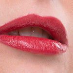 A close-up of lips wearing Benecos Natural Lipsticks 4.5g in glossy red, slightly parted to reveal white teeth. The background is soft pink with "Just Red" text at the bottom.