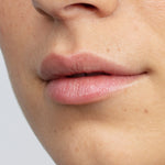 Model with hydrated lips wearing Antipodes Kiwi Seed Oil Lip Conditioner