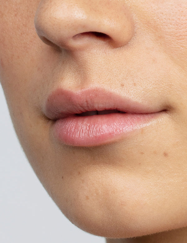 Model with hydrated lips wearing Antipodes Kiwi Seed Oil Lip Conditioner