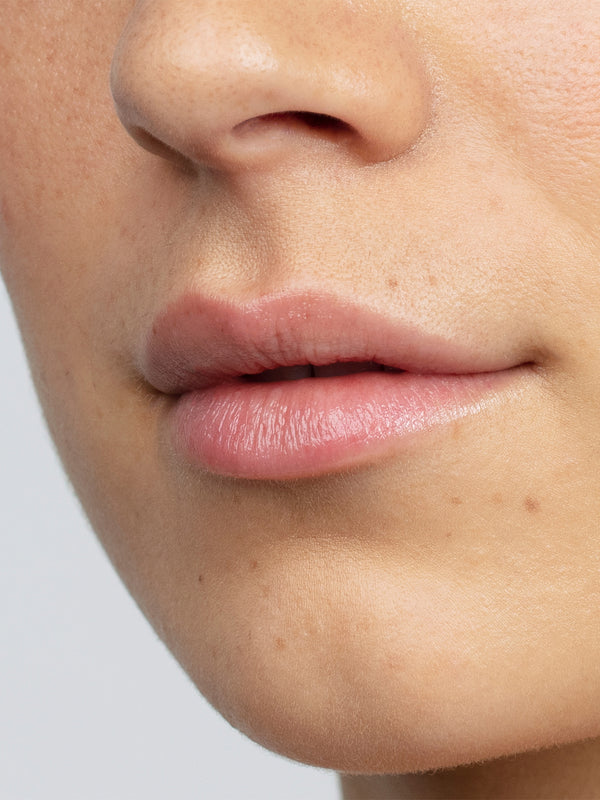Model with hydrated lips wearing Antipodes Kiwi Seed Oil Lip Conditioner