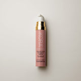 Small dusty-pink 10 ml KORA Kakadu Plum Vitamin C Serum bottle with a white pump and gold collar, lying on a warm grey surface.