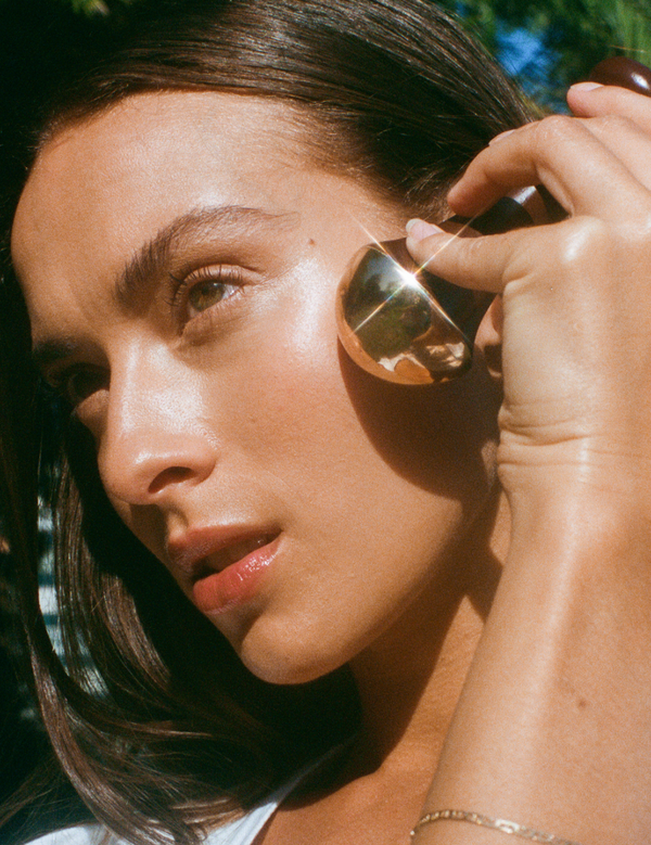 Model using the LAMAV Ayurvedic Kansa Wand on her face