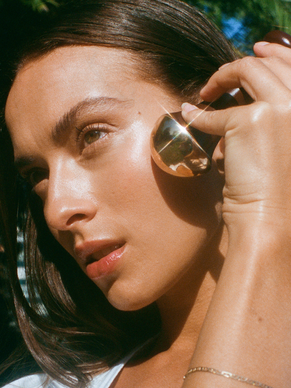 Model using the LAMAV Ayurvedic Kansa Wand on her face