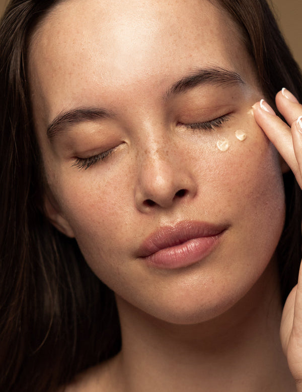 Model applying Antipodes Kiwi Seed Gold Luminous Eye Cream