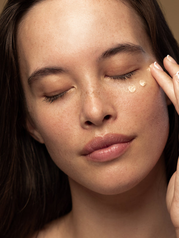 Model applying Antipodes Kiwi Seed Gold Luminous Eye Cream