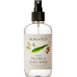 A clear spray bottle labeled Koala Eco Pillow and Linen Spray Rosalina, Peppermint & Eucalyptus 250ml, with eucalyptus and peppermint illustrations, a black nozzle, and an eco-friendly formula for freshening linens.