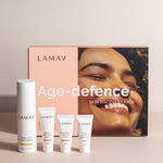 The LAMAV Age-Defence Skin Discovery Pack (4 Pack) is displayed in front of its box, featuring a smiling face—ideal for those seeking organic, anti-ageing skincare from LAMAV.