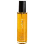 A clear bottle of LAMAV Ayurvedic Body Oil Nourish 120ml with a black cap, containing golden organic oil. The label reads LAMAV Ayurvedic Body Oil NOURISH and shows a volume of 120ml (4.06 fl oz).