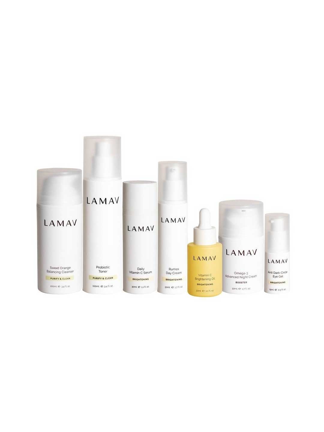 Seven LAMAV Age-Defence Complete Skincare Collection products for oily/combination skin are arranged in a row against a white background, featuring minimalistic white packaging with black text labels.