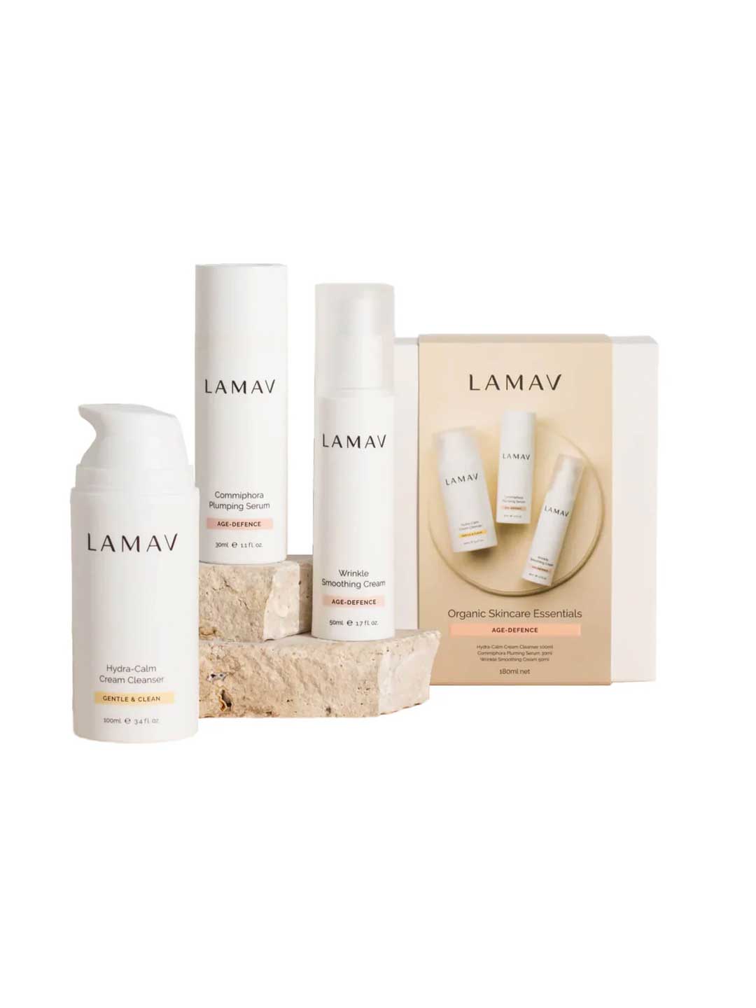 The LAMAV Age-Defence Skin Discovery Pack (3 Pack) and branded box are shown on a white background with two stone pieces. The minimalist white packaging highlights LAMAV’s dedication to vegan skincare.