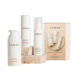 The LAMAV Age-Defence Skin Discovery Pack (3 Pack) and branded box are shown on a white background with two stone pieces. The minimalist white packaging highlights LAMAV’s dedication to vegan skincare.